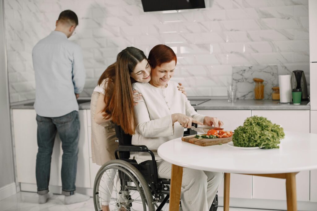 Woman in wheelchair cooking with family in a bright kitchen, showcasing love and togetherness.